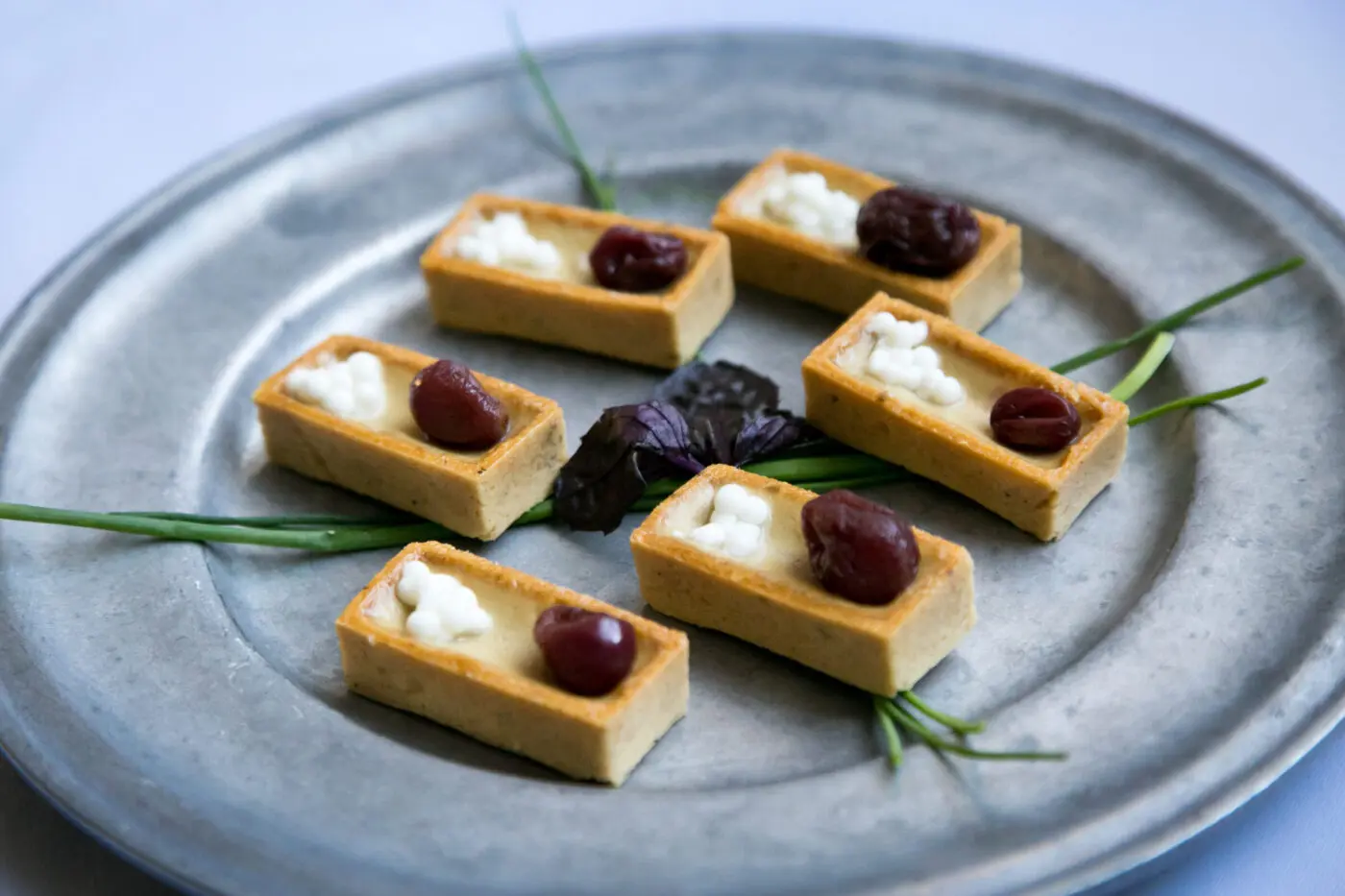 Hors d'oeuvres arranged on a gray dish.