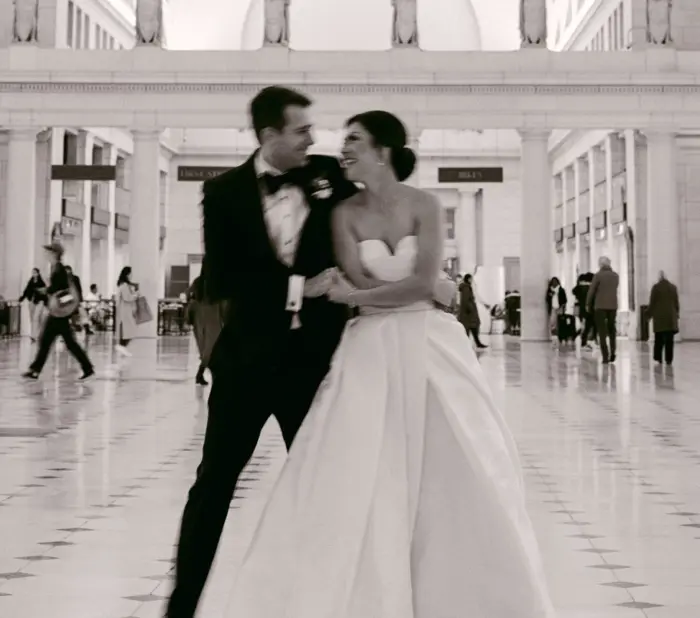Black and white photo of bride and groom holding hands