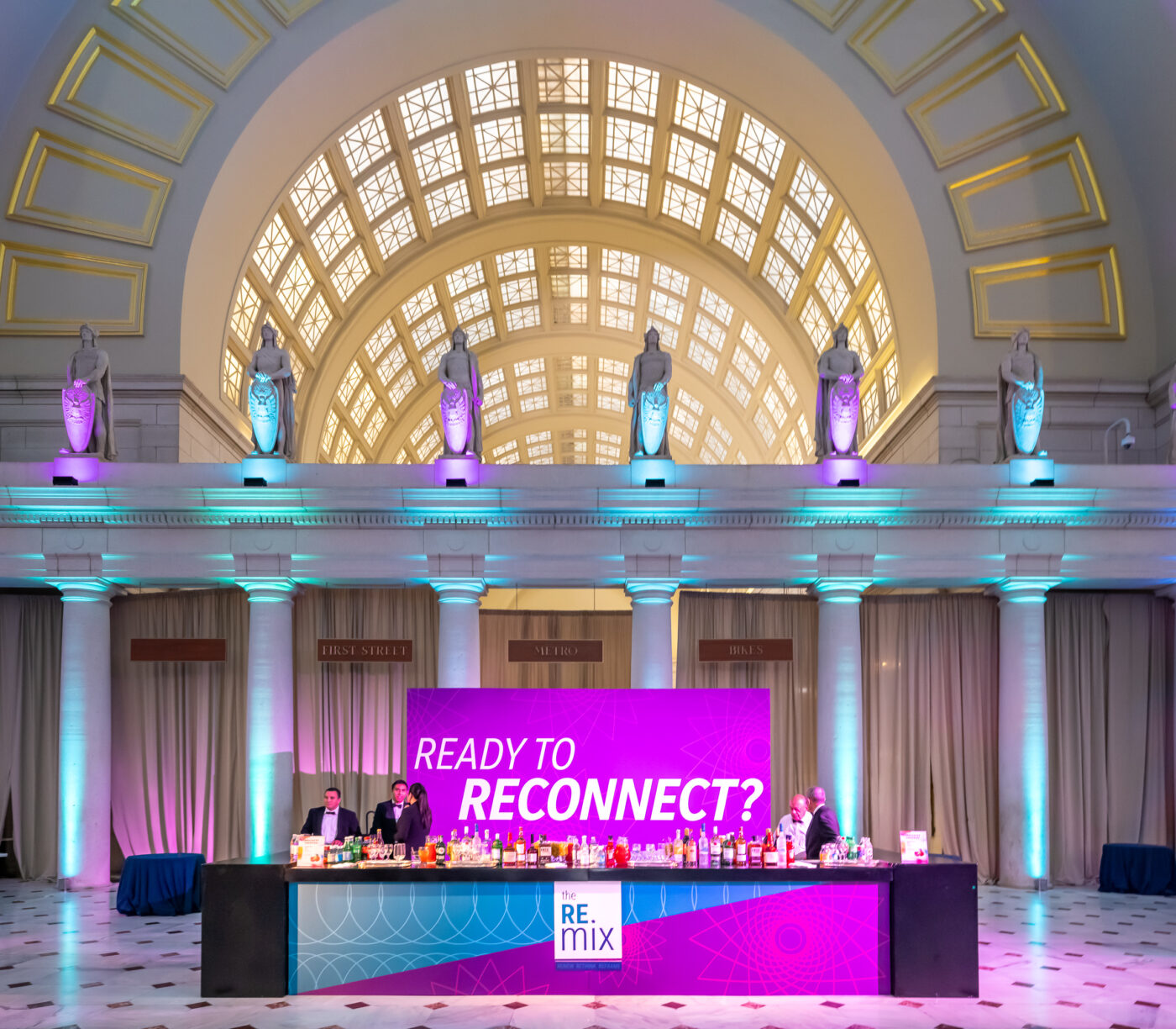 An interior space of Union Station set up for an event. A purple and blue bar with a sign reading 