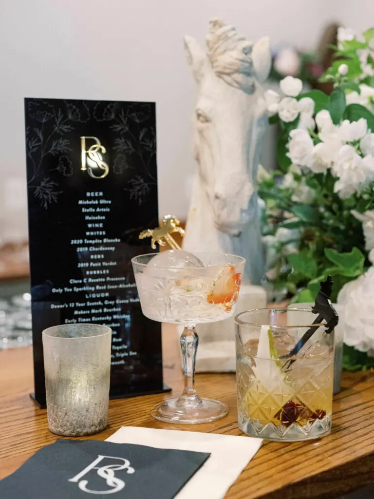 Details from the bar show a black upright drink menu and two cocktails in decorative glasses.